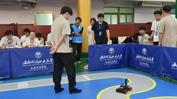 欧冠押注球赛押注app2025年6月26日，我校新能源汽车专业学生在两项机器人竞赛中斩获佳绩，24级新能源汽车学生王艺谋（黑色衣服）在运行智能小车.jpg